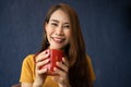 Smile young Asian woman holding a red cup and enjoying drinking warm coffee in the morning, Concept of relaxation in leisure and