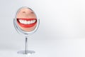 The smile of a young woman with clean and beautiful white teeth Red lips Reflections on the mirror set on the white table. Royalty Free Stock Photo