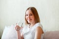 Smile young woman drinks glass of pure water in morning after waking up in her bed room. Happy teen girl maintains water Royalty Free Stock Photo