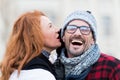 Smiled guy listen to woman. Very happy man from woman story. Woman whispers to man in glasses. Close up of man opened mouth.