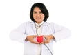 Smiled kindness asian female doctor standing and holding red heart in her hands isolated on white background Royalty Free Stock Photo