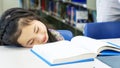 Smiley asian cute girl sitting and sleeping with book on the tab