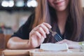 A smiley beautiful woman cutting and eating blueberry cheese cake in wooden plate with fork Royalty Free Stock Photo