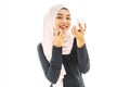 smiley beautiful young muslim woman wearing Hijab and painting her lips with a lipstick with mirror on white background Royalty Free Stock Photo