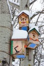 Smiley birdhouses. Birdhouse in the form of a funny face on the tree. Handmade wooden nesting box covered in snow. Winter landscap