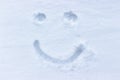 Smiley drawing in the snow. Woman in the fresh, untouched snow. Graza and smile, emoji Royalty Free Stock Photo