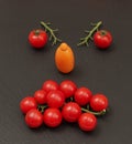 Smiley face with a angry expression. Laying out parts of a human face with vegetables, namely tomatoes and tomato branches