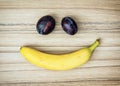 Smiley face of banana and plums, emotions, fruit theme Royalty Free Stock Photo