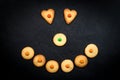 Smiley face of childish cookies on black background Royalty Free Stock Photo