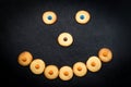 Smiley face of childish cookies on black background Royalty Free Stock Photo