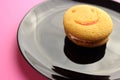 Smiley face cookies in a black plate on a pink background Royalty Free Stock Photo