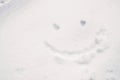 Smiley face drawing on snow floorin winter season Royalty Free Stock Photo