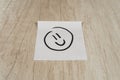 a smiley face drawn with black marker pen on a sticky note positioned in the center Royalty Free Stock Photo