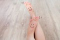 Smiley Face Drawn on Toes. Close Up Female Barefoot On Wooden Floor Background Royalty Free Stock Photo