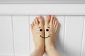 Smiley Face Emotion Barefoot. Beautiful Female Feet on Pink Fabric Bedroom Background Royalty Free Stock Photo