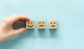 Smiley face mental health assessment positive. Hand putting excellent emotion wood cube block. Royalty Free Stock Photo