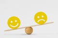 Smiley face and sad face on scale - Concept of happiness as predominant emotion Royalty Free Stock Photo