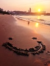 Smiley face in sand romantic sunset at city beach Royalty Free Stock Photo