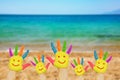 Smiley on hands against beach background. Royalty Free Stock Photo