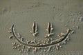 Smiley happy face drawn on sand at beach Royalty Free Stock Photo