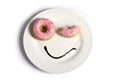 Smiley happy face made on dish with donuts blinking eye and chocolate syrup as smile in sugar and sweet addiction