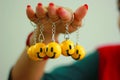 Smiley key rings hanging from fingers of a lady, symbol of joy