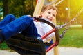 Smiley little boy riding on a swing
