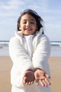 Smiley little girl in white coat playing on beach Royalty Free Stock Photo