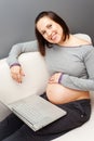 Smiley pregnant woman with laptop Royalty Free Stock Photo