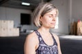 Smiley relaxed mid adult woman resting meditating in easy pose with eyes closed in her yoga practice Royalty Free Stock Photo