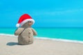 Smiley sandy Snowman in red Santa hat at sea beach Royalty Free Stock Photo