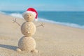 Smiley sandy snowman in santa hat. Holiday concept for New Years