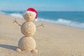 Smiley sandy snowman in santa hat. Holiday concept for New Years