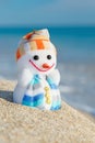 Smiley toy snowman at sea beach. Royalty Free Stock Photo