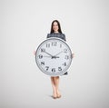 Smiley woman holding big white clock Royalty Free Stock Photo