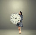 Smiley woman looking at big white clock Royalty Free Stock Photo