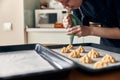 beautiful caucasian lady cook is making eclairs with help of pastry casing at home