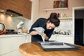 beautiful caucasian lady cook is making eclairs with help of pastry casing at home