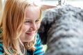 Smiley young blonde girl looking into the face of her black dog Royalty Free Stock Photo