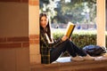 Smiley young girl sitting on the window at the university terrac Royalty Free Stock Photo