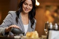 Smiley young lady adding soy sauce from tiny bottle