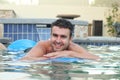 Smiley young man floating on a mattress in water pool Royalty Free Stock Photo