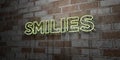 SMILIES - Glowing Neon Sign on stonework wall - 3D rendered royalty free stock illustration