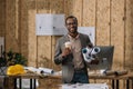 smilign african american architect with coffee to go and rolled blueprints Royalty Free Stock Photo