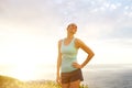Smiling active woman standing outside during sunset Royalty Free Stock Photo