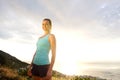 Smiling active woman standing by the sea during sunset