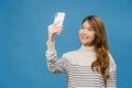 Smiling adorable Asian female making selfie photo on smart phone with positive expression in casual clothing and stand isolated on Royalty Free Stock Photo