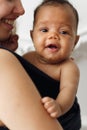 Smiling adorable baby with happy mother in sling