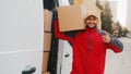 Smiling delivery man showing thumb up and looking at camera Royalty Free Stock Photo