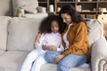 Smiling affectionate young African American mother and daughter using cellphone. Royalty Free Stock Photo